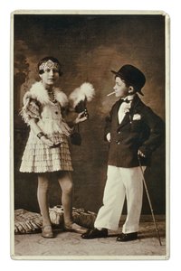 1920年代のファッションに身を包んだ大人に扮した2人の子供。少女はチャールストン用の衣装を、彼はスーツ、ボーラーハット、タバコを身につけている。写真