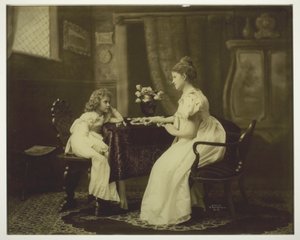 テーブルでドミノをしている女性と子供 作： Unknown