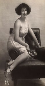 肘掛け椅子に座り、ペチコート姿でポーズをとる若い女性。 作： Unknown photographer