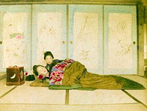 布団の上でリクライニング。床に敷かれた伝統的な布団の上でリクライニングする2人の日本人女性。日本、1910年頃。日本、東アジア、アジア。©Cultural Heritage Images/UIG/Leemage 作： Unknown photographer