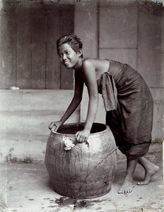 大きなコンテナを押しながら微笑む若いタイ人女性 作： Unknown photographer