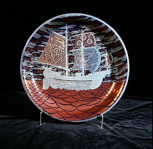 赤色の海に帆を張るガレオン船を描いた銀色光沢のチャージャー（陶製） 作： William de Morgan