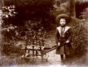 庭でカートを持つ少女、20 世紀初頭 (白黒写真) 作： . .