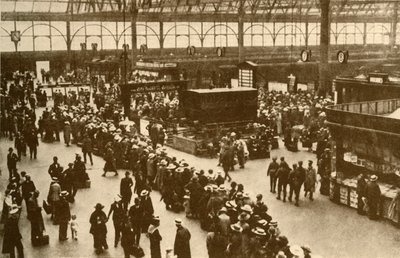 「ロンドンのウォータールー駅で電車を待つ行楽客の列」、1930 年。 作： Alfieri