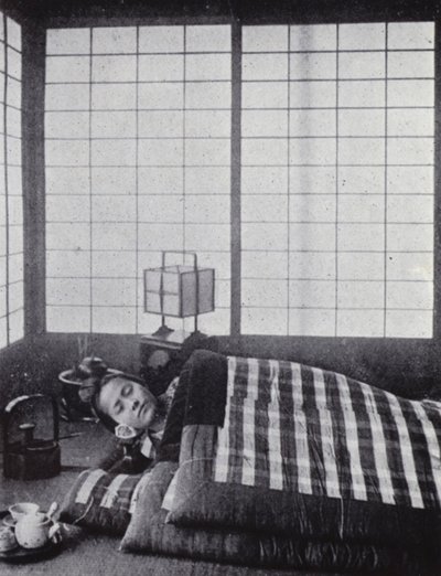 木製の枕を持って、わたがしのような布団の間で眠る少女（モノクロ写真 作： American Photographer (after)