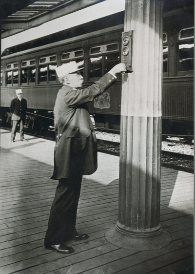 1910年、ワシントンD.C.で「ロイヤル・ブルー」の出発を告げる車掌（モノクロ写真 作： American Photographer