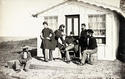 5人の南北戦争兵士が家の外のダートポーチに集まり、アフリカ系アメリカ人の若者が彼らの近くに座った、1861-65 作： American Photographer