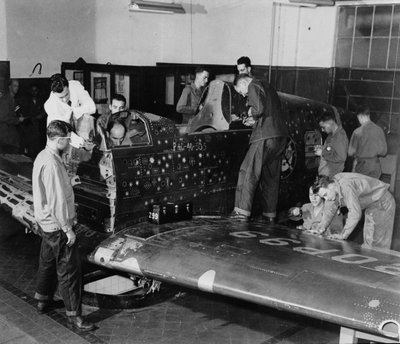 兵士の訓練生は、シミュレーションの弾痕とパッチ、c.1942を備えた、カーティスの「ウォーホーク」戦闘機「フライングパッチ」に取り組んでいます。 作： American Photographer