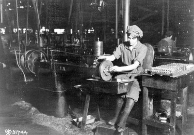1914〜18年の第一次世界大戦中にペンシルベニア州エディストーンのライフルライフル工場のフロントサイトキャリアのキーシートをブローチする女性 作： American Photographer