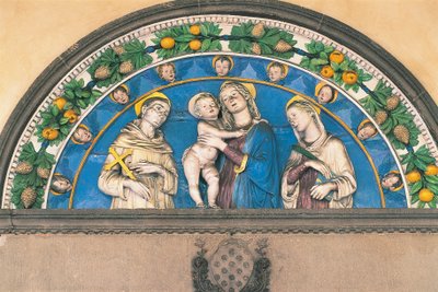 聖人に挟まれた子連れの聖母を描いた釉薬付きテラコッタ・ルネット 作： Andrea Della Robbia
