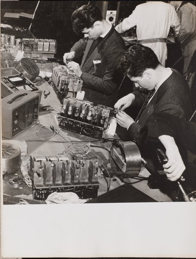 [ブレザーを着た2人の若者が無線で作業している] 作： Arnold Eagle