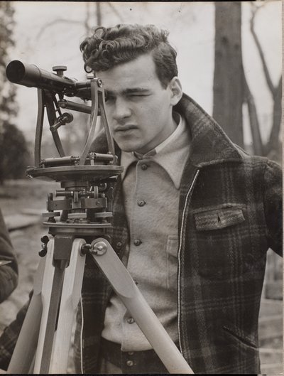 [若い男が測量器具を覗き込む] 作： Arnold Eagle