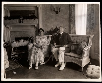 1916-6年、ニューヨークの5番街200番地にある自宅の居間でポーズをとったハワード氏とハワード氏の肖像画（銀ゼラチンプリント） 作： Byron Company