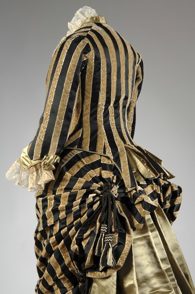 イブニング・ドレス、1884年頃（背面斜め部分図）。シルクサテンとカットベルベット、レース、絹糸のタッセルとフリンジ。チャールズ・フレデリック・ワース、フランス。 作： Charles Frederick Worth