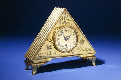 花の装飾が刻まれた三角形の真鍮製テーブルクロック（真鍮 作： Dagobert (attr. to) Peche