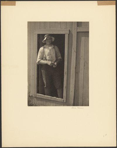 [納屋の戸口に立つ麦わら帽子の男、煙草入れを持つ]。 作： Doris Ulmann