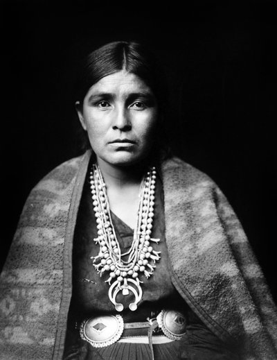 Navajo nainen yllään hopea squash kukka kaulakoru, concho vyö, viltti ladattuna olkapäille, c. 1904, valokuva Edward S. Curtis 作： Edward Sheriff Curtis