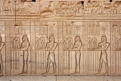 エジプトの古代文明：女神に捧げられた供物と貢物（エジプト、デンデラのハトホル神殿） - エジプトの文明：女神に捧げられた供物と貢物 - デンデラのハトホル神殿（またはテンティラ神殿）の壁に彫られた人物像。 作： Egyptian Ptolemaic Period