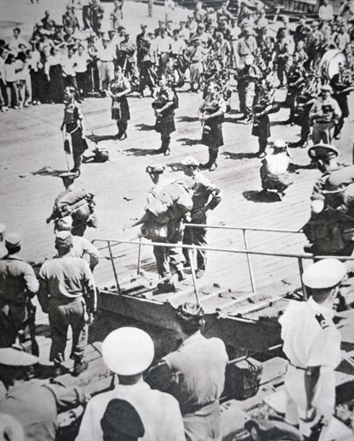 1950年8月29日、釜山のHMSセイロンからアーガイル・アンド・サザーランド・ハイランダーズ第1大隊に上陸したキルト・パイパーの演奏（モノクロ写真 作： English Photographer