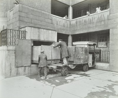 Ossulston Estate：ダストマンがゴミシュートの底にある容器を空にする 作： English Photographer