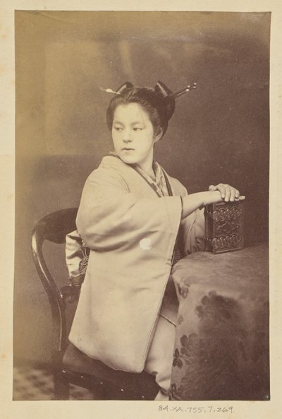 [テーブルでカルト・ド・ヴィジットのアルバムを手にする日本人女性] 作： Felice Beato