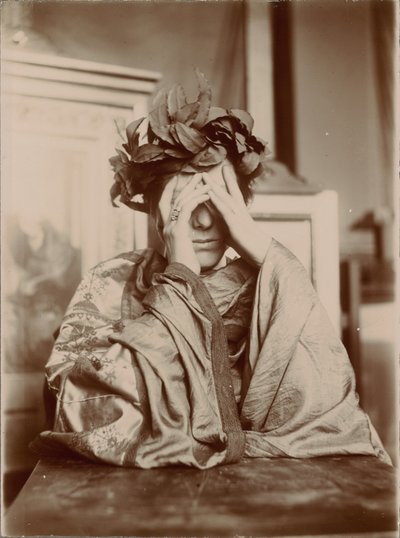 テーブルにもたれかかり、両手を顔の前に置く女性。 作： Fernand Khnopff