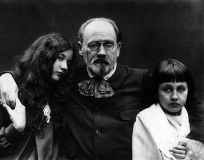 作家・フランス人ジャーナリストのエミール・ゾラ（1840-1902）は、ヴェルヌイユ・シュル・セーヌ（イヴリンヌの）の自宅の庭で、子供のドゥニーズとジャックと一緒に過ごしています。- エミール・ゾラ（1840-1902）、フランスの作家、ジャーナリスト、ヴェルヌイユ・シュル・セーヌ（イヴリンズ）の自宅で、子供たちと一緒に 作： French Photographer