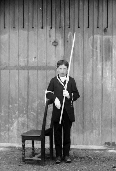 白い衣装と手袋を身につけ、メダル、ロザリオ、白いレースのカフを持ち、非常に長いロウソクを身につけた初聖体拝領者、オートマルヌ（オートマルヌ県）のブルモン近く、1880年頃。写真撮影。デュコス・コレクション。 作： French Photographer