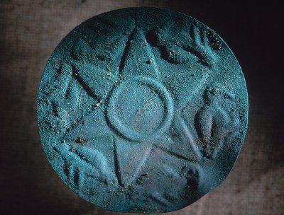 学校の南側で発掘された銅製の星は、かつて杖と葦で作られた戦士の盾を飾っていた。それはトゥパック神父と一緒に発見された。 作： Ira Block
