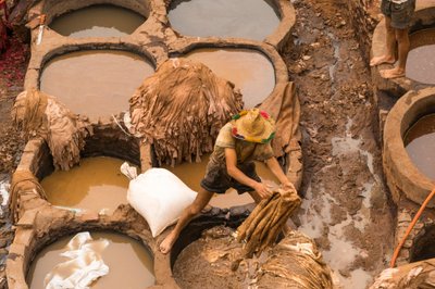 モロッコ、フェスのChouaraタンナーで染色される皮革、2014年（写真）。 作： Ira Block