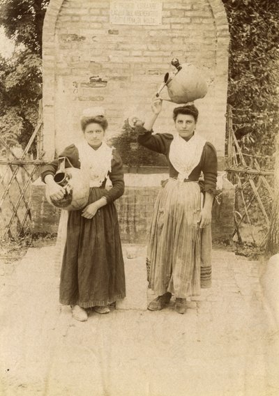 井戸の近くで伝統的な服を着てテラコッタの壺を運ぶ2人の若い女性（イタリア、マルケ州、1910年頃 作： イタリアの写真家