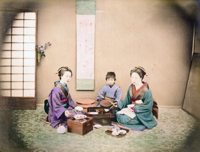 2人の女性と子供がマットの上に座って昼食をとっている、1890年頃（手描きの写真） 作： Japanese Photographer