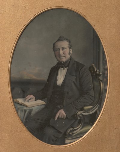 開いた本の通路を指している座っている男、1850 年代。 作： John Jabez Edwin Mayall