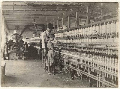 [サウスカロライナのコットン工場、紡績機に向かう少女と男]。 作： Lewis W. Hine