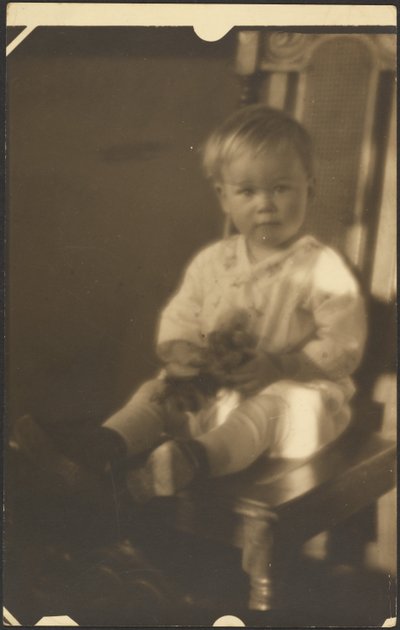 [大きな椅子に座る子供] 作： Louis Fleckenstein