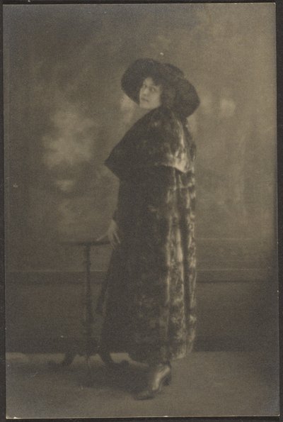 [タペストリーの前に長いコートを着た女性の肖像]。 作： Louis Fleckenstein