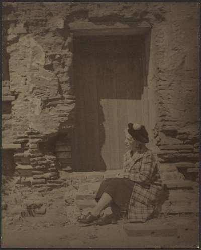 [老朽化したビルの前に座る女性］ 作： Louis Fleckenstein