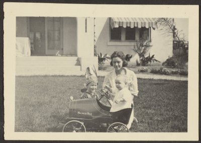 [おもちゃの車に子供を乗せた女性］ 作： Louis Fleckenstein