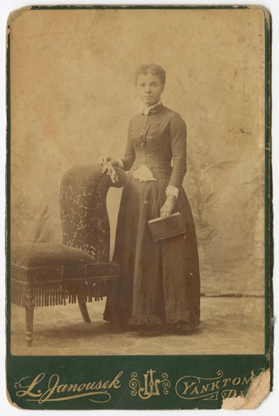 椅子の横に立って本を持っている女性の写真 19世紀後半 作： Louis Janousek