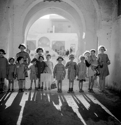 アーチの下で学生服を着たヨーロッパの子供たちの影。 作： Maynard Owen Williams