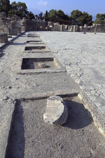 ミノア時代のファイストスの遺跡。西翼の祠堂から中庭を見たところ。中庭はミノアの宮殿の基本的な建築要素である。中庭は、ミノアの宮殿の基本的な建築要素であり、各翼を取り囲むように配置された核である。この中庭は、かつては 作： Minoan