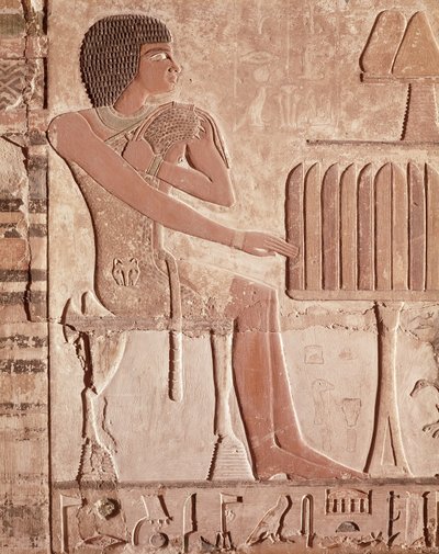 パン（塗られた石）が付いている供物台の前に座っている故人を描いたレリーフ 作： Old Kingdom Egyptian