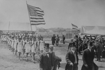 アメリカとフィリピンの選手団が日本の要人の後ろを行進しています。 作： Paul Thompson