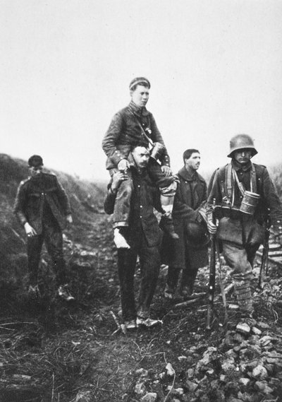 足を負傷したドイツ人歩兵がイギリス人捕虜に担がれて戦場を離れる様子（モノクロ写真 作： Photographer German