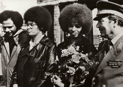 1972年9月11日、アメリカの共産主義者で公民権運動家のアンジェラ・デイヴィスは、ドイツ民主共和国の国家人民軍の兵士たちからブランデンブルク門で心のこもった歓迎を受けた（モノクロ写真）。 作： Photographer German