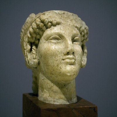 少女の頭（コレ）、ローマ・ヘレニズム時代（3～2世紀）の彫刻、非常に表情豊かな顔、東側に突き出た頬骨、微笑み、巻き毛、前6世紀のイオニの古風なスタイルが後に長く続いた 作： Roman