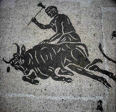 雄牛の屠殺シーンを描いたモザイクで、オスティア（Ostia）（ローマ近郊）で発見された。現在は旧オスティアの消防署に保存されている。 作： Roman Roman