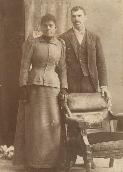 椅子の後ろに立っているアフリカ系アメリカ人のカップルの写真。 1890年。 作： Schmitz Studio