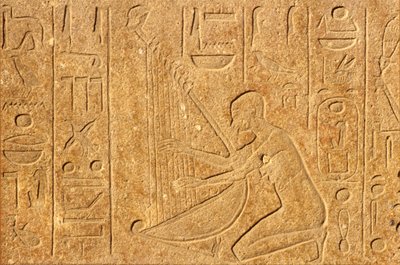 古代エジプト、ルクソール、カルナック神殿、ハープの上にハトシェプスト像の頭を乗せたハープ奏者。 作： School Egyptian