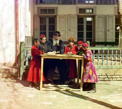 1905年から1915年の間にロシア帝国サマルカンドの家の前のテーブルに教師がいるユダヤ人の子供たちのグループ 作： Sergey Prokudin Gorsky